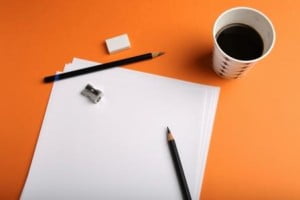 Paper, pencil, coffee and a sharpener symbolising procrastination